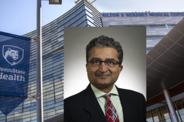 A headshot photo of Dr. Thiru Annaswamy is placed over a stock photo of Hershey Medical Center.