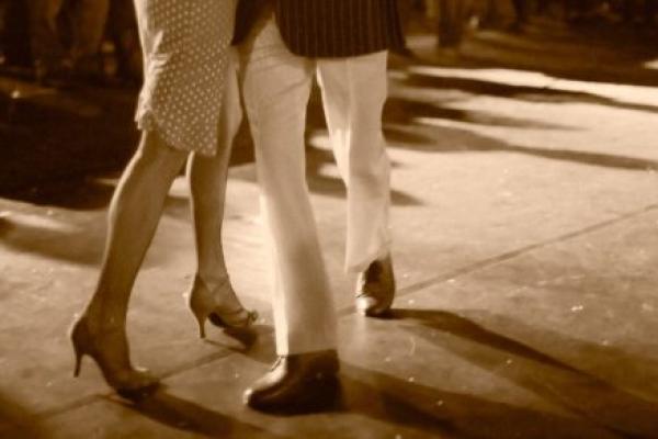 A man and woman dance in front of a crowd.