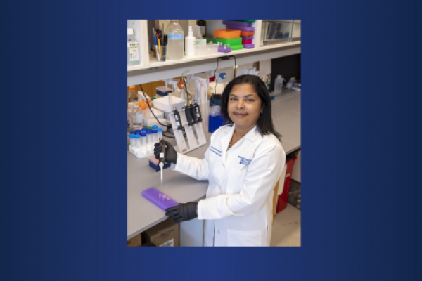 A woman wearing a white doctor's coat works in a laboratory