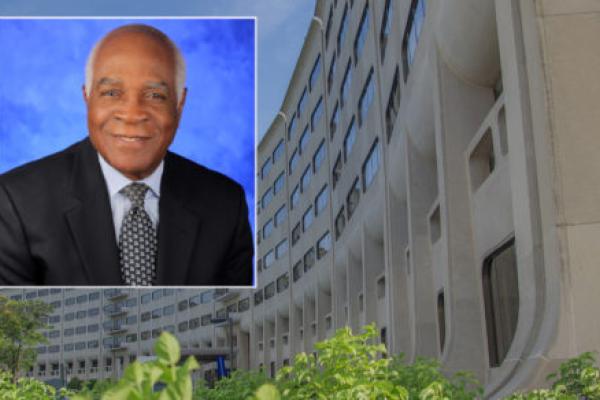 Dr. Rodrigue Mortel smiles in a professional portrait. He is wearing a suit, tie and shirt.
