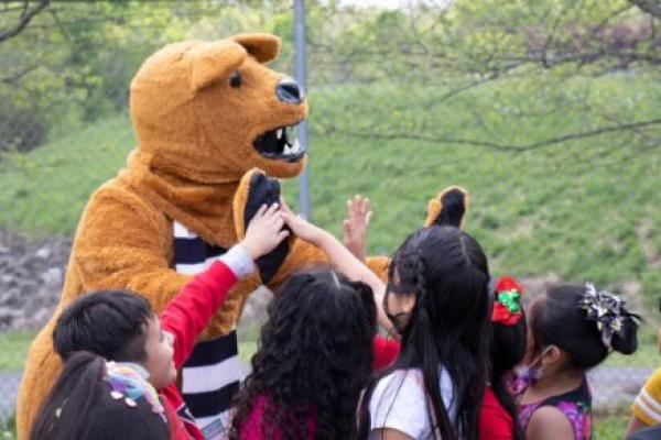 The Nittany Lion cheers on children.